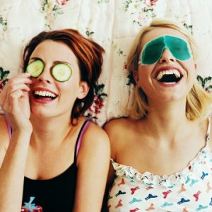 Two Female Teenagers Lying in Bed Wearing Eye Masks